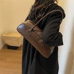 Trendy Women’s Baguette Shoulder Bag woman handling coffee color bag